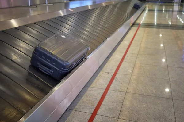 Maleta perdida en la cinta del carrusel de equipaje del aeropuerto — Foto de Stock
