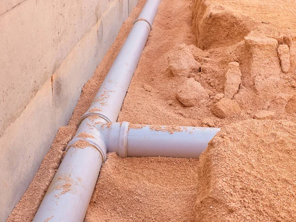 Junction of plastic sewer pipes. Sewage pipeline system of residential building under construction.
