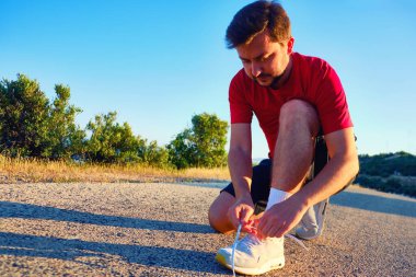 Sabahları bağcıklarını bağlayan adam kırsalda koşuyor..