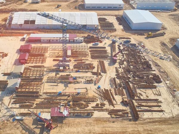 outdoor warehouse at construction site with tower crane aerial view toned.