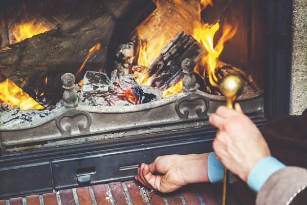 Mão abre fogo panela de cinzas que queimam lenha — Fotografia de Stock