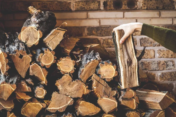 Męskiej ręki bierze kawałek drewna z sterach stos drewna opałowego — Zdjęcie stockowe