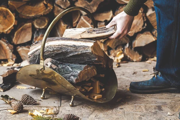 Hand man zet stuk hout in metalen houtstapel — Stockfoto