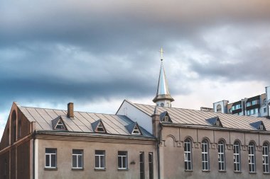 Binayı Katolik Kilisesi ile spire bulutların arka planda
