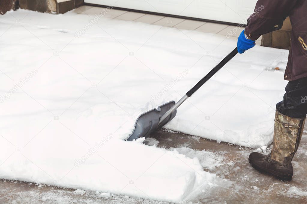 Shoe shovel snow. man cleans snow boots in plastic shovel