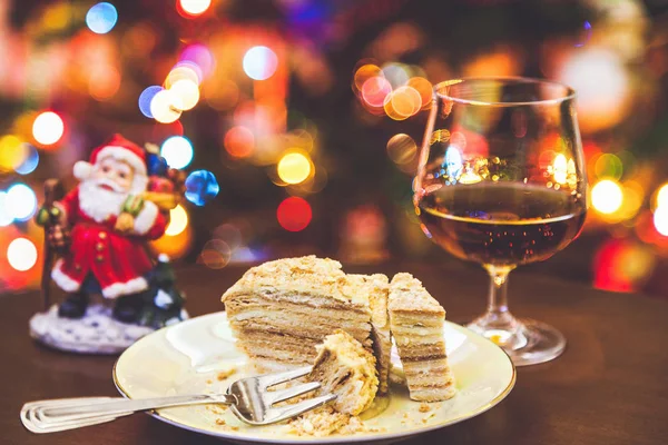 Christmas dessert. Cake on plate and glass of cognac in