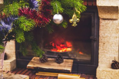 Noel ağacı ile odun yanan şömine önünde duruyor