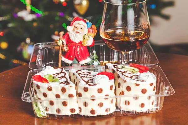 Christmas dessert. Cognac, Santa Claus and set of cakes