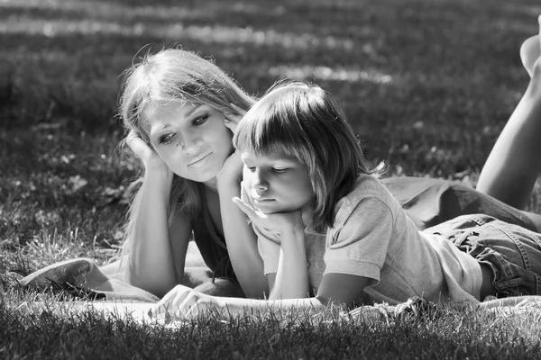 Rodinná idyla. Matka a syn na trávníku monochromatický obraz — Stock fotografie