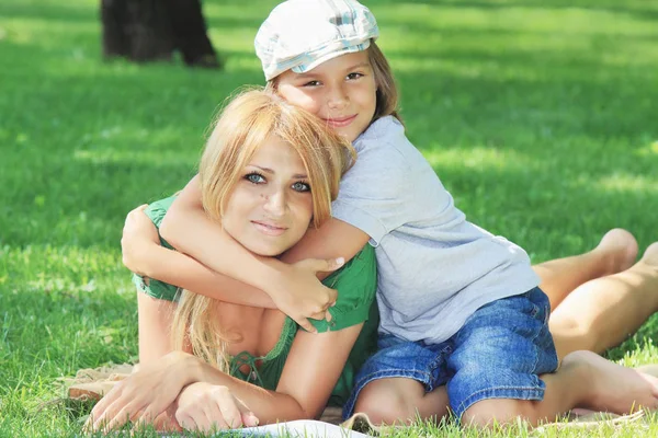 Friendly cute family on a green grass lawn — Stock Photo, Image