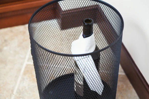 Bottle wine in an empty trash can — Stock Photo, Image