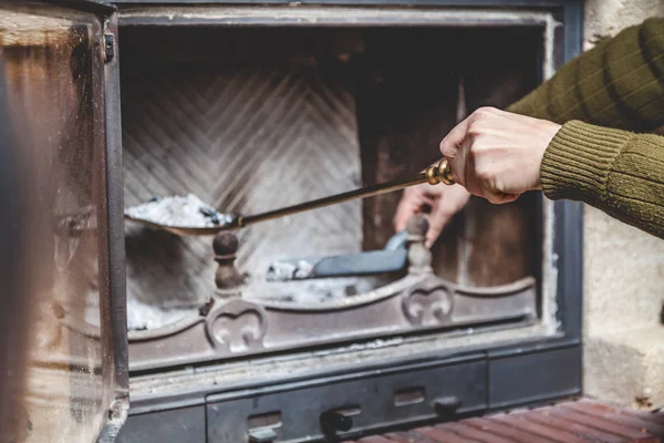 Cleaning  fireplace. Hand holding  shovel with ash — Stock Photo, Image