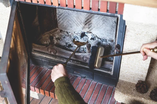 Man cleans fireplace with brush and blades — Stock Photo, Image