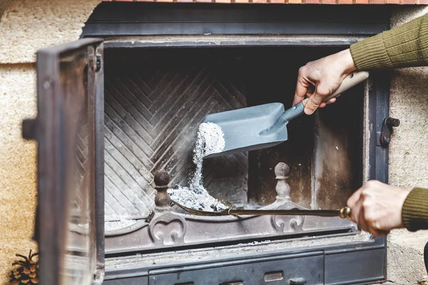 Cleaning fireplace. man pours ashes of  blades in blade — Stock Photo, Image