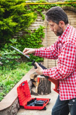 adam ekose gömlekli ekler aracında testere ile kesme