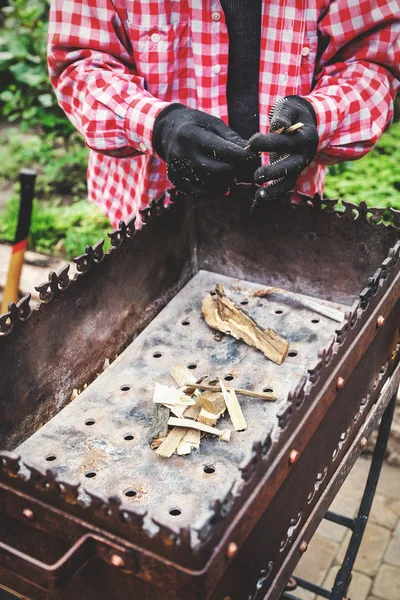 Мужчина собирается построить пламя в металлическом брезенте — стоковое фото