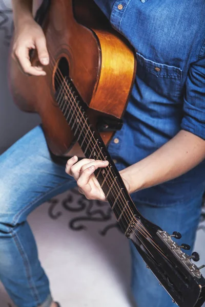 Man in jeans clothes playing an acoustic guitar — Stock Photo, Image