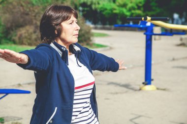 Şirin emekli kadın jimnastik egzersizleri Caddesi üzerinde gerçekleştirir.