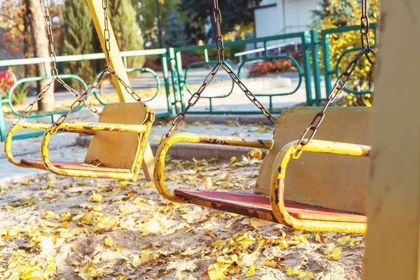 Дві порожні гойдалки на дитячому майданчику осінь — стокове фото