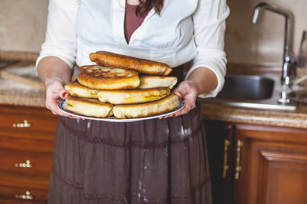 Тарелка с жареными пирогами в женских руках — стоковое фото