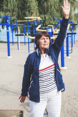 Şirin emekli kadın jimnastik egzersizleri Caddesi üzerinde gerçekleştirir.