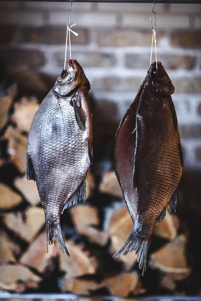 İki büyük füme balık yığılmış yakacak odun özgeçmişlerine asmak