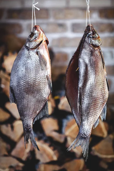 İki büyük füme balık yığılmış yakacak odun özgeçmişlerine asmak