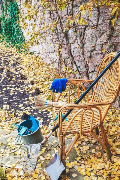 Antes de limpiar. Equipo de limpieza hojas a silla de mimbre — Foto de Stock