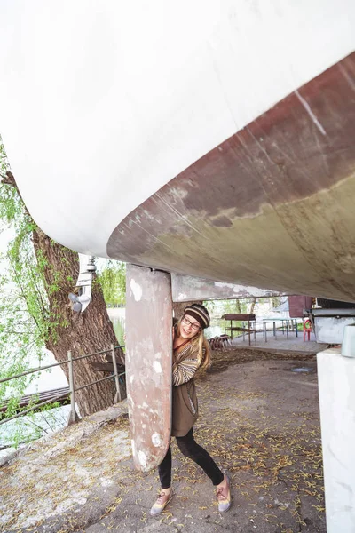 Giovane ragazza si nasconde dietro un grande yacht chiglia — Foto Stock