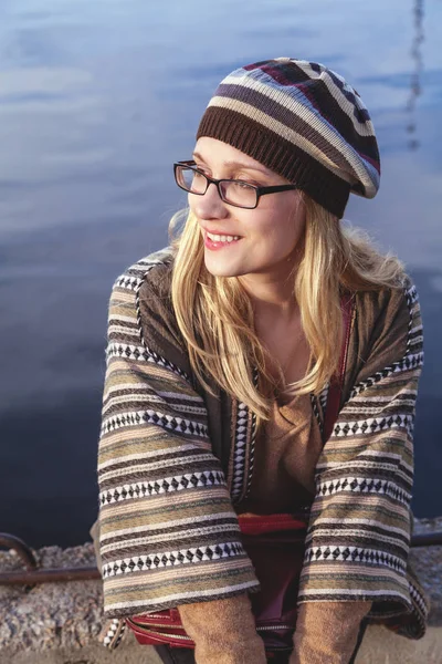 Jeune blonde à lunettes assise sur le quai — Photo