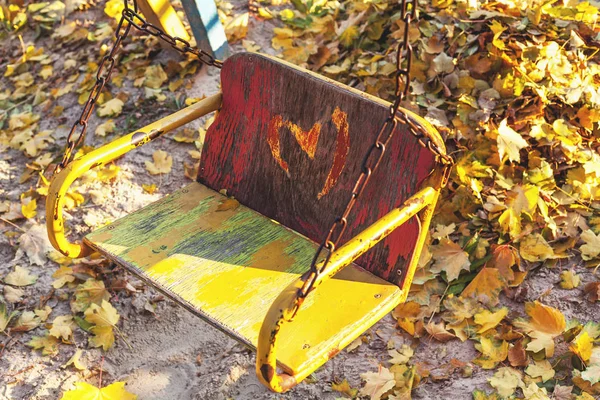 Columpio de los niños vacíos en el sitio de otoño —  Fotos de Stock