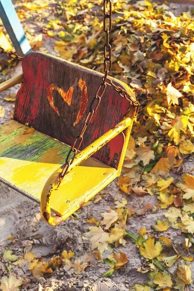 Columpio de los niños vacíos en el sitio de otoño —  Fotos de Stock