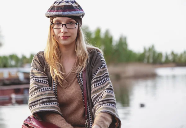 戴着眼镜，一顶贝雷帽的女孩坐在海湾 — 图库照片