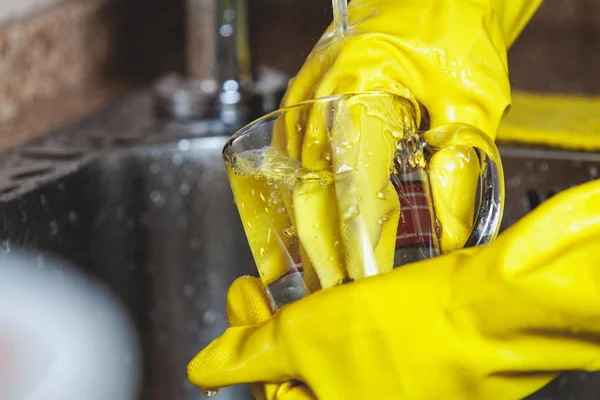 Las manos en guantes de goma amarilla lavan tazas de té — Foto de Stock