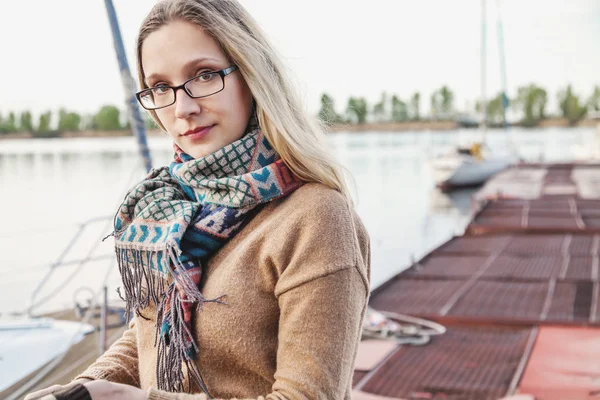 Young woman wearing a scarf standing on the dock — Stock Photo, Image