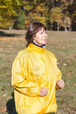 Güzel Olgun kadın sonbahar ormanda koşu