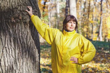 Yaşlı kadın sonbahar ormanda yürür