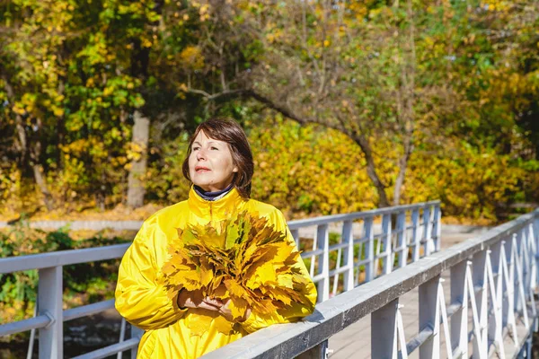 Grup yaprakları ile köprüde duran güzel büyük kadın