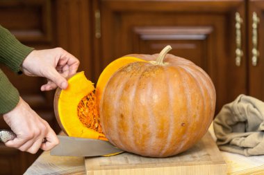 Eller erkek olgun kabak parçası büyük bıçak ile kesmek.