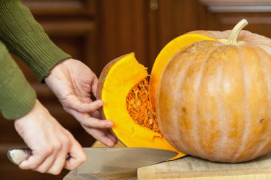 Eller erkek olgun kabak parçası büyük bıçak ile kesmek.