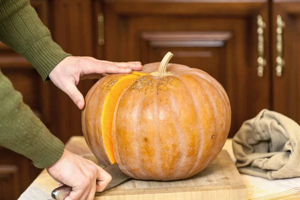 Eller erkek olgun kabak parçası büyük bıçak ile kesmek.