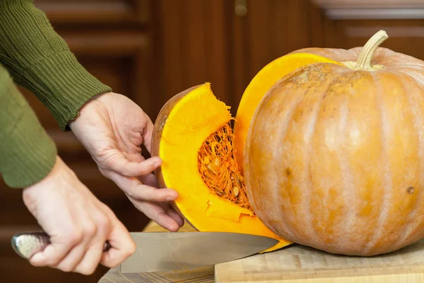 Eller erkek olgun kabak parçası büyük bıçak ile kesmek.