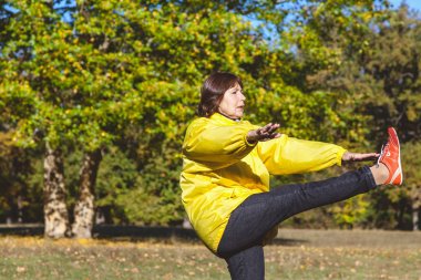 Bir orman glade egzersiz olgun güzel kadın