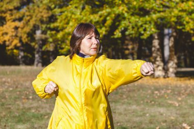 Bir orman glade egzersiz olgun güzel kadın