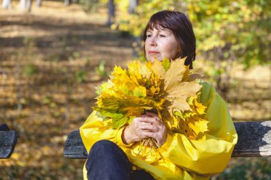 Düşen akçaağaç tutan güzel büyük kadın bırakır