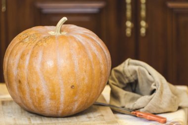 bıçak ve çanta yanında kesme tahtası üzerinde büyük kabak