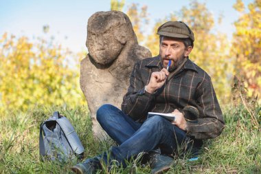 öğrenilen tarihçi önce taş heykel Höyük üzerinde oturur.
