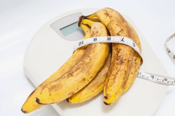 Bunch of bananas lying on floor scales on white background — Stock Photo, Image