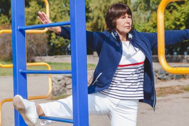 yaşlı kadın gerçekleştirir yaz çömelme spor zemin