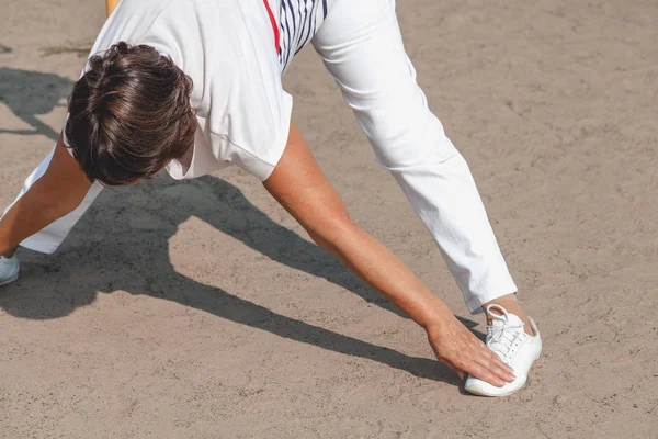 Gymnastik på stranden. pensionerad kvinna utför övningar på sandstranden g — Stockfoto
